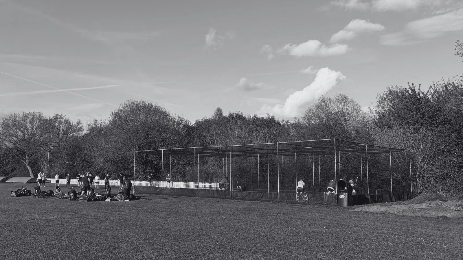 Cricket practice nets with players training on a grassroots cricket ground