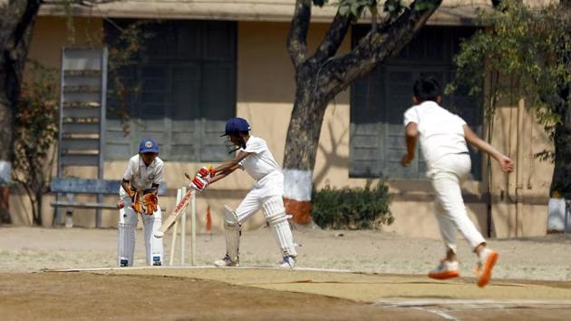Young cricket players in India playing on a grassroots pitch, representing the India-UK exchange programme
